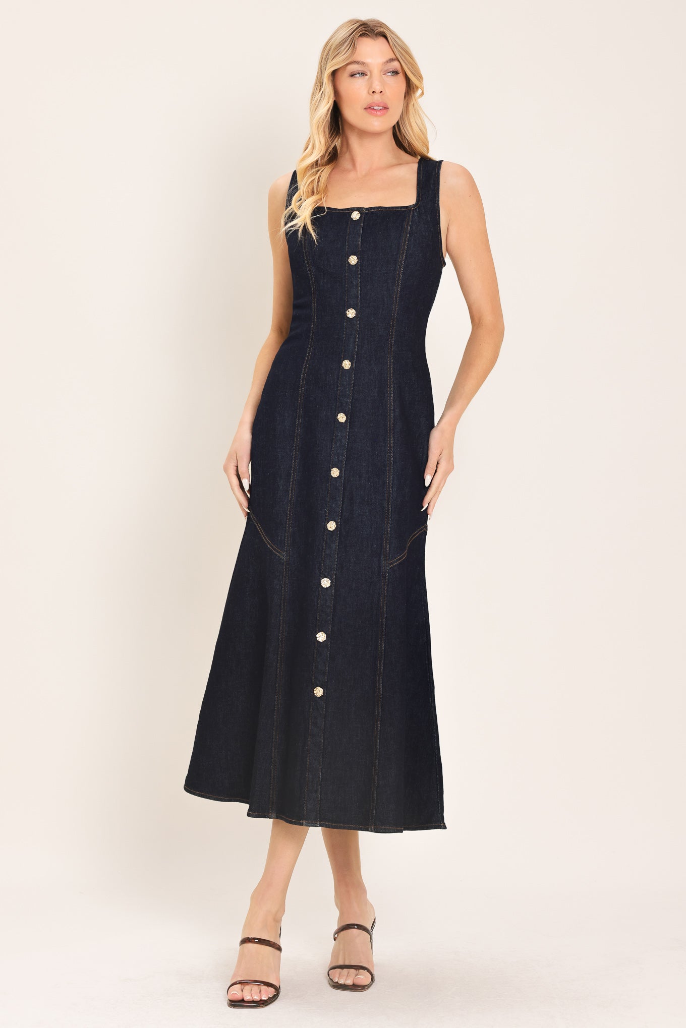 Woman wearing a dark indigo denim sleeveless midi dress with buttons | Flying Tomato