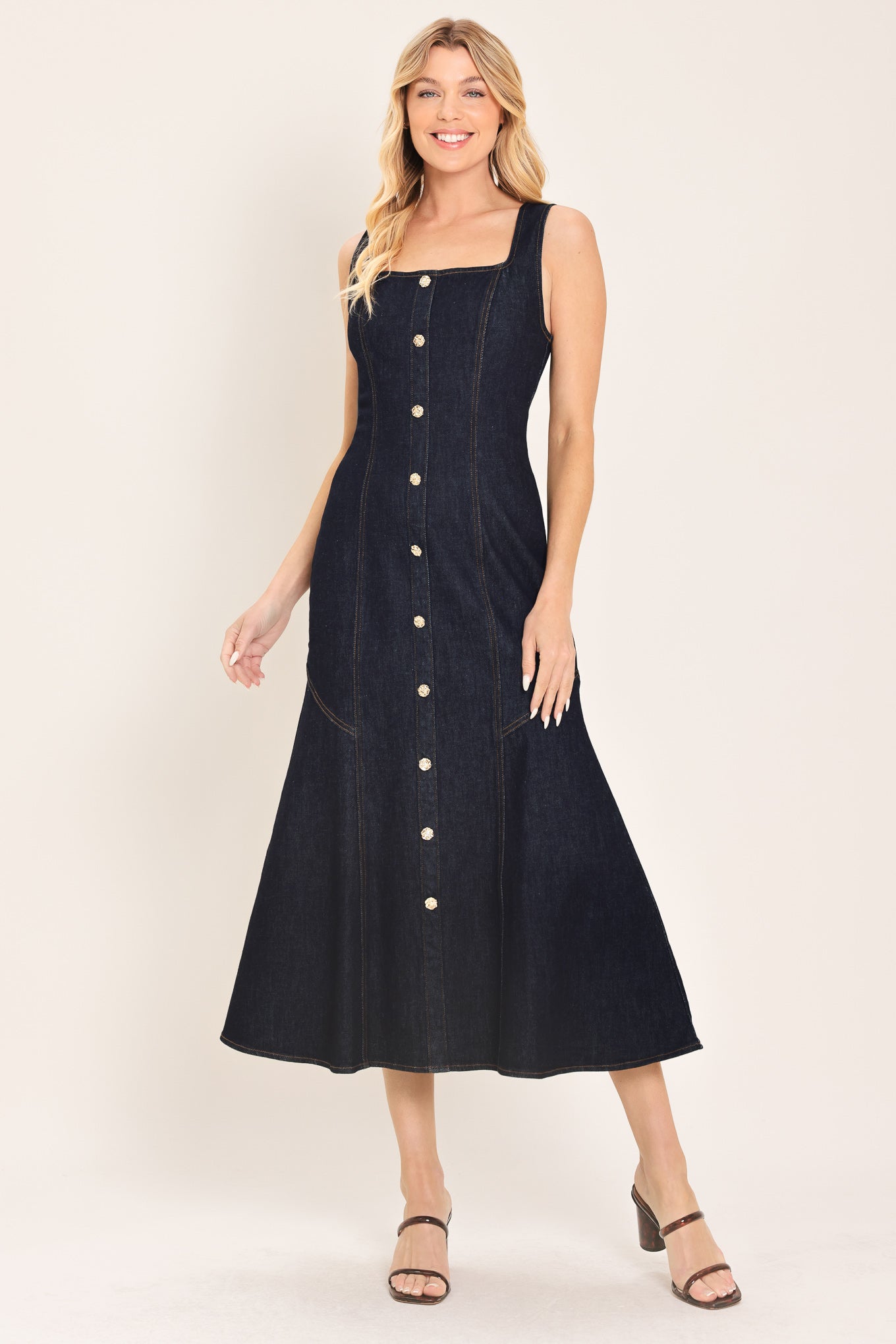 Woman wearing a dark indigo denim sleeveless midi dress with buttons | Flying Tomato