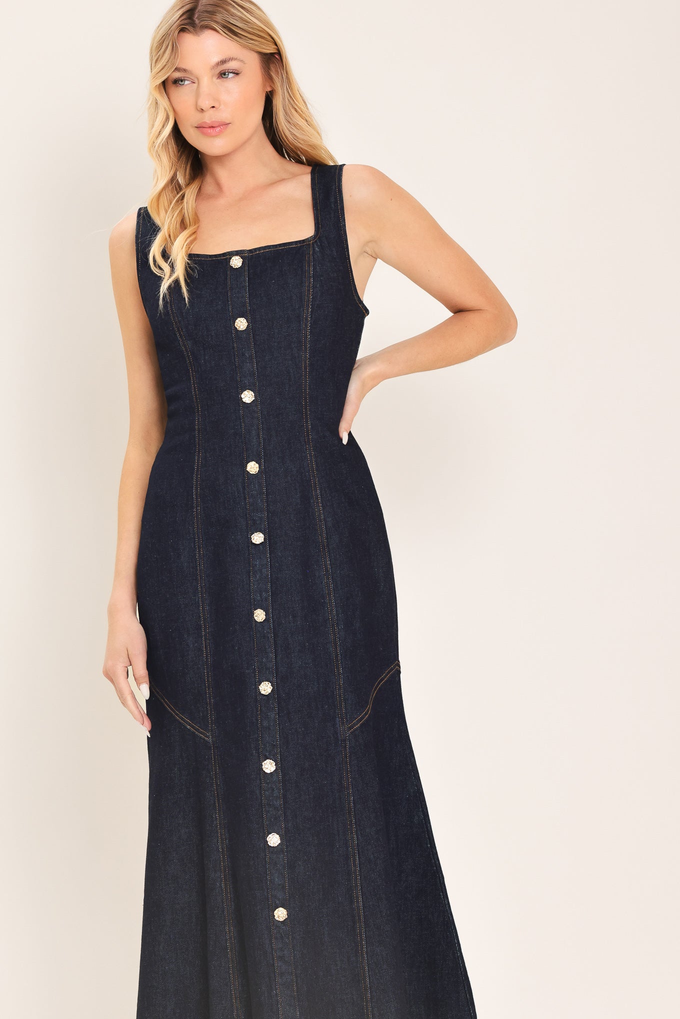 Woman wearing a dark indigo denim sleeveless midi dress with buttons | Flying Tomato