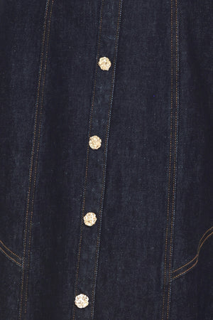 Woman wearing a dark indigo denim sleeveless midi dress with buttons | Flying Tomato