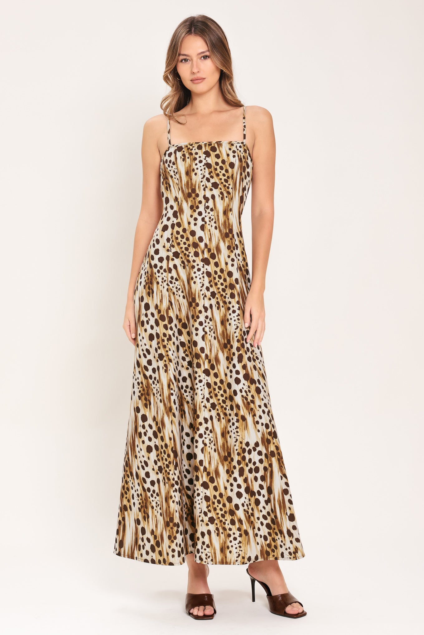 Woman wearing a leopard print maxi dress featuring straight neckline, straps and back zipper closure | Flying Tomato