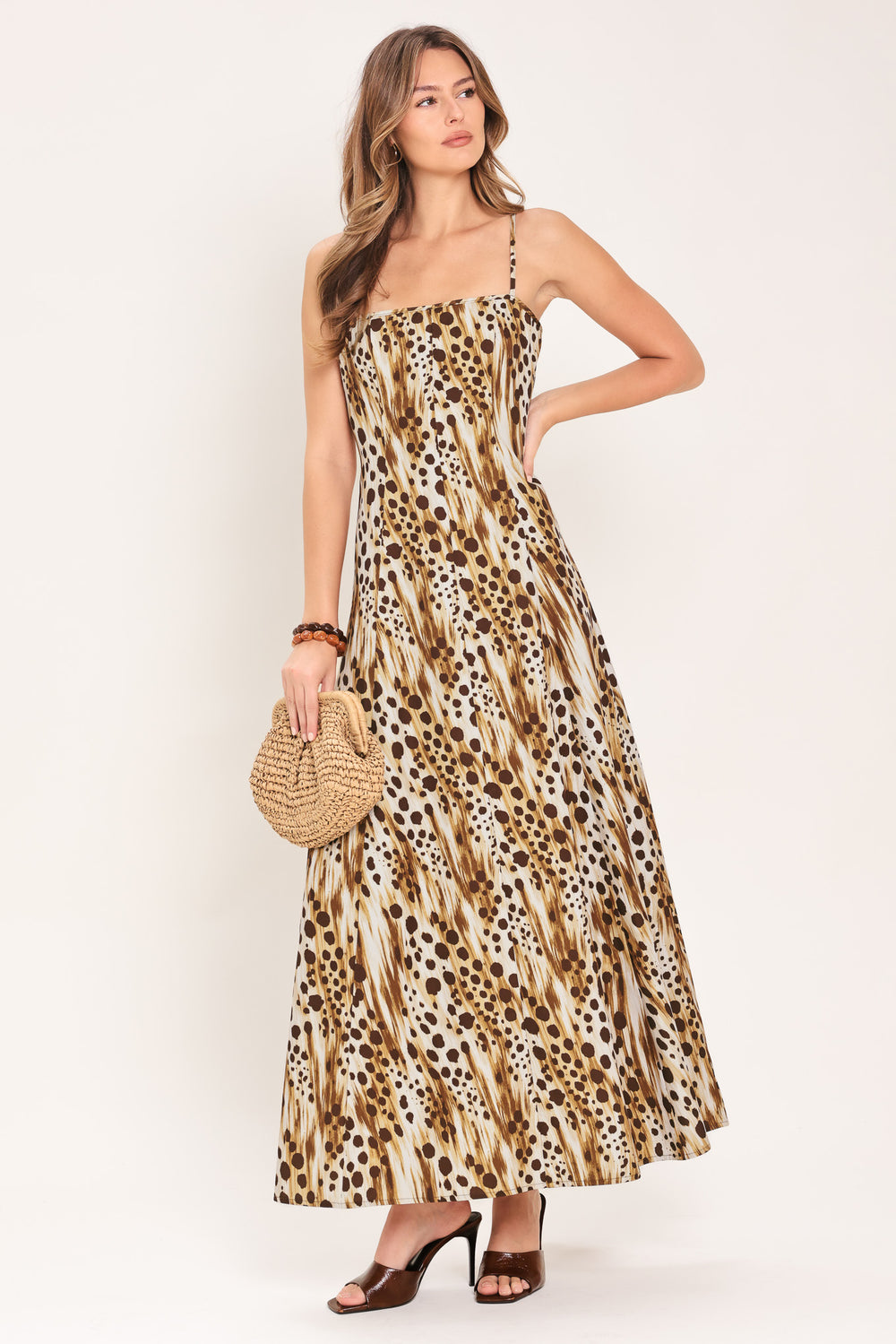 Woman wearing a leopard print maxi dress featuring straight neckline, straps and back zipper closure | Flying Tomato