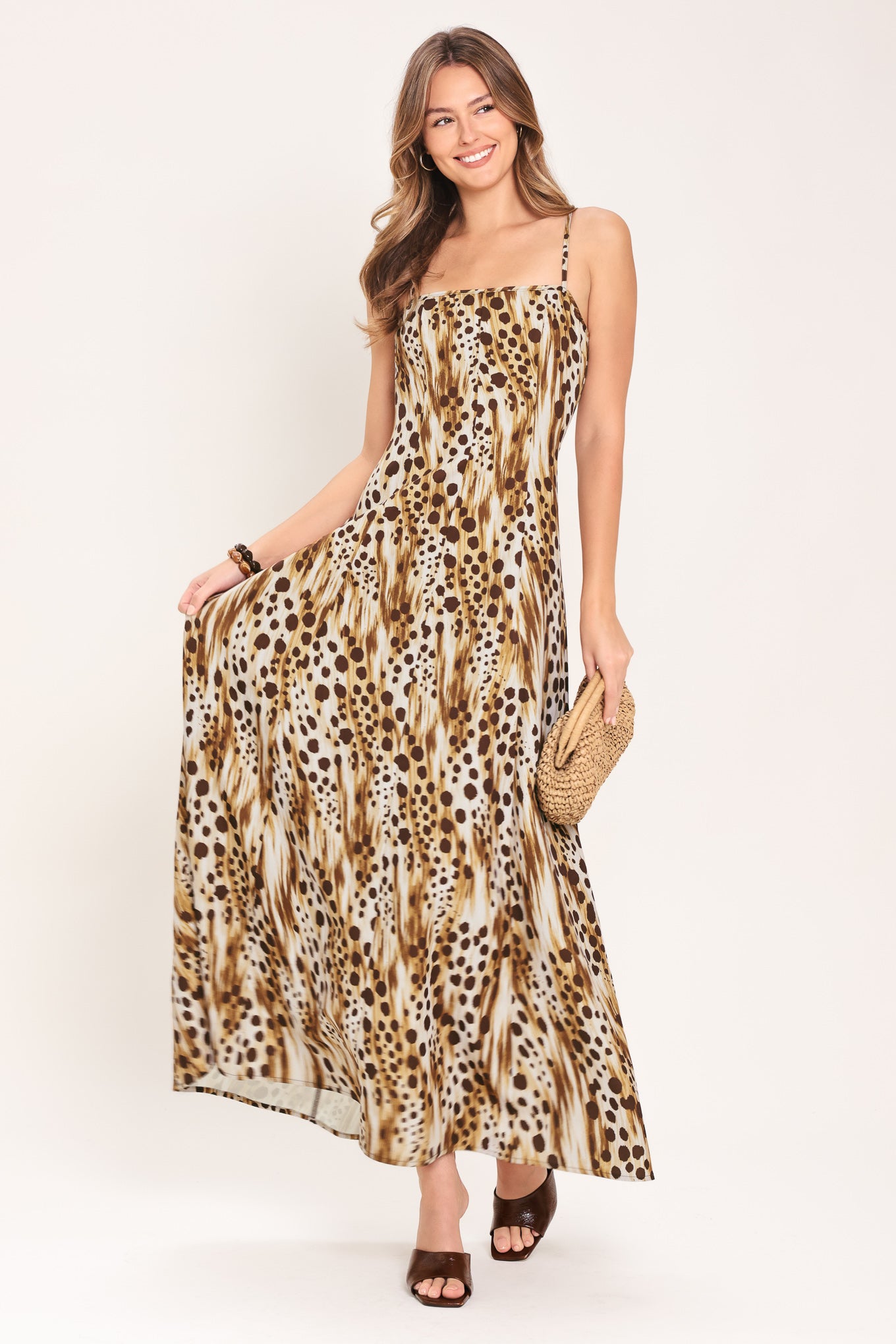 Woman wearing a leopard print maxi dress featuring straight neckline, straps and back zipper closure | Flying Tomato