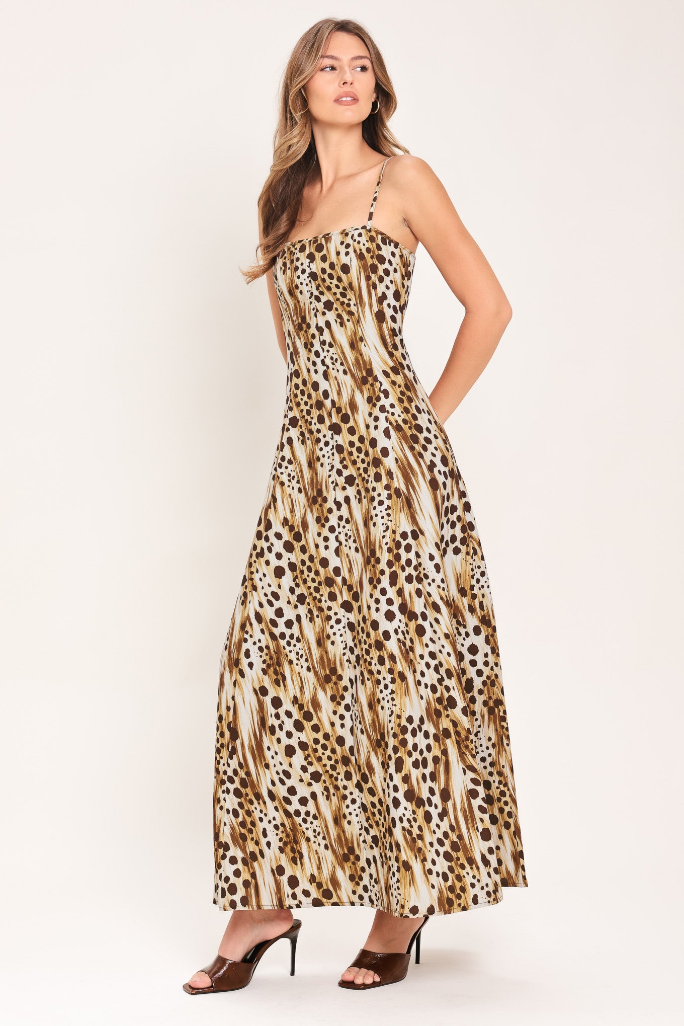 Woman wearing a leopard print maxi dress featuring straight neckline, straps and back zipper closure | Flying Tomato