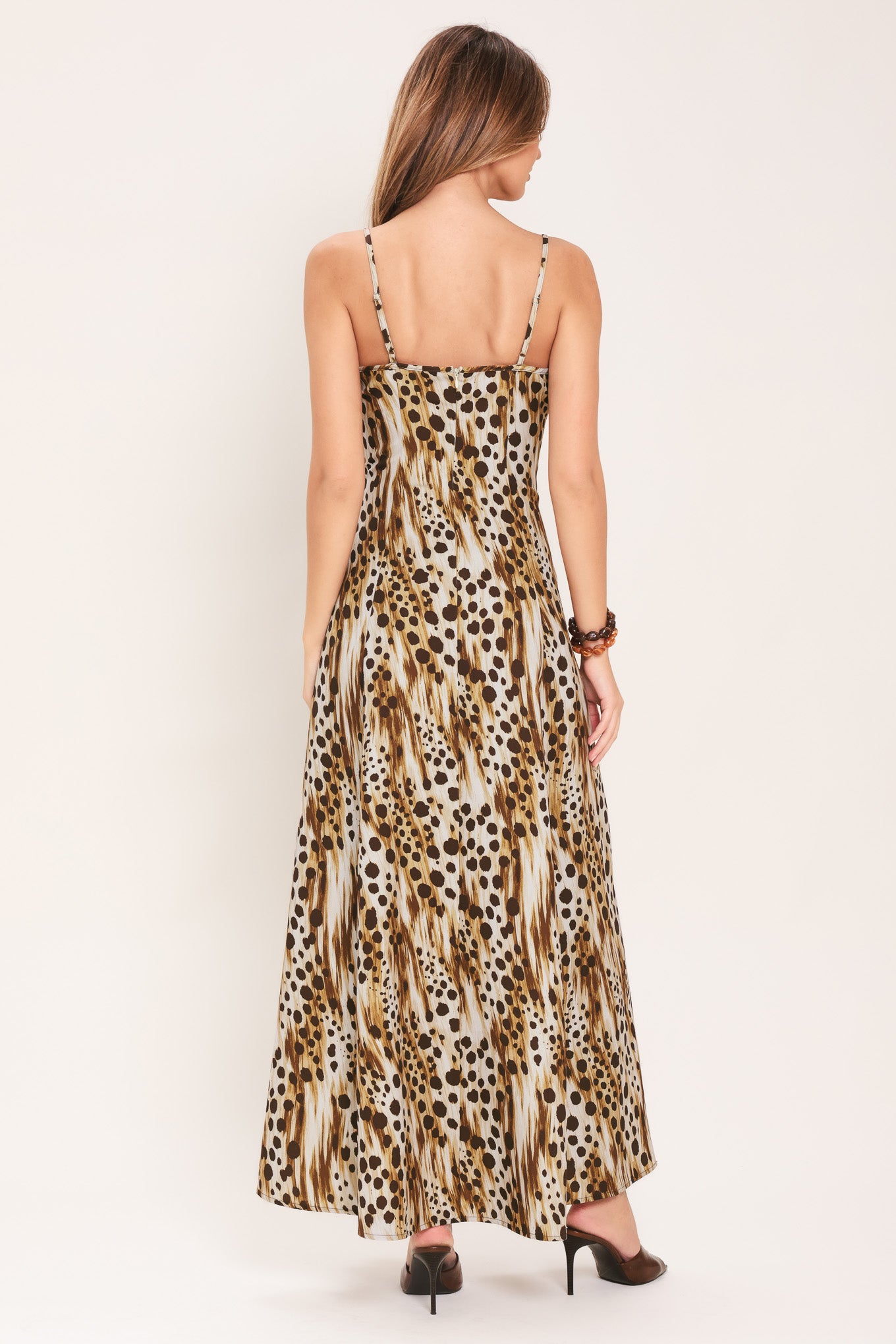 Woman wearing a leopard print maxi dress featuring straight neckline, straps and back zipper closure | Flying Tomato