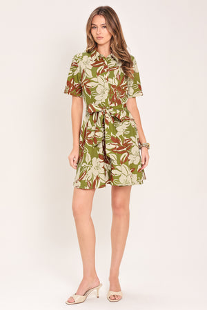 Woman wearing an olive green floral mini shirt dress with front button closure, short sleeve, self sash and full skirt | Flying Tomato