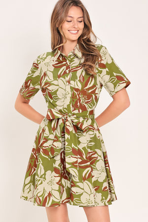 Woman wearing an olive green floral mini shirt dress with front button closure, short sleeve, self sash and full skirt | Flying Tomato
