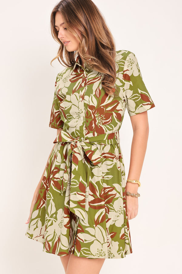 Woman wearing an olive green floral mini shirt dress with front button closure, short sleeve, self sash and full skirt | Flying Tomato