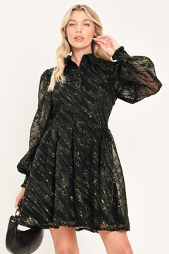 A model wearing a black sheer mini dress with gold glittery diagonal stripes, featuring long balloon sleeves and a flared skirt | Flying Tomato
