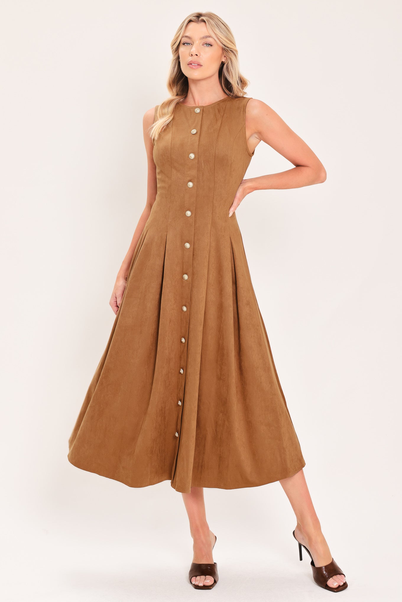 A woman modeling a sleeveless, midi-length camel brown faux suede dress with a button-down front | Flying Tomato