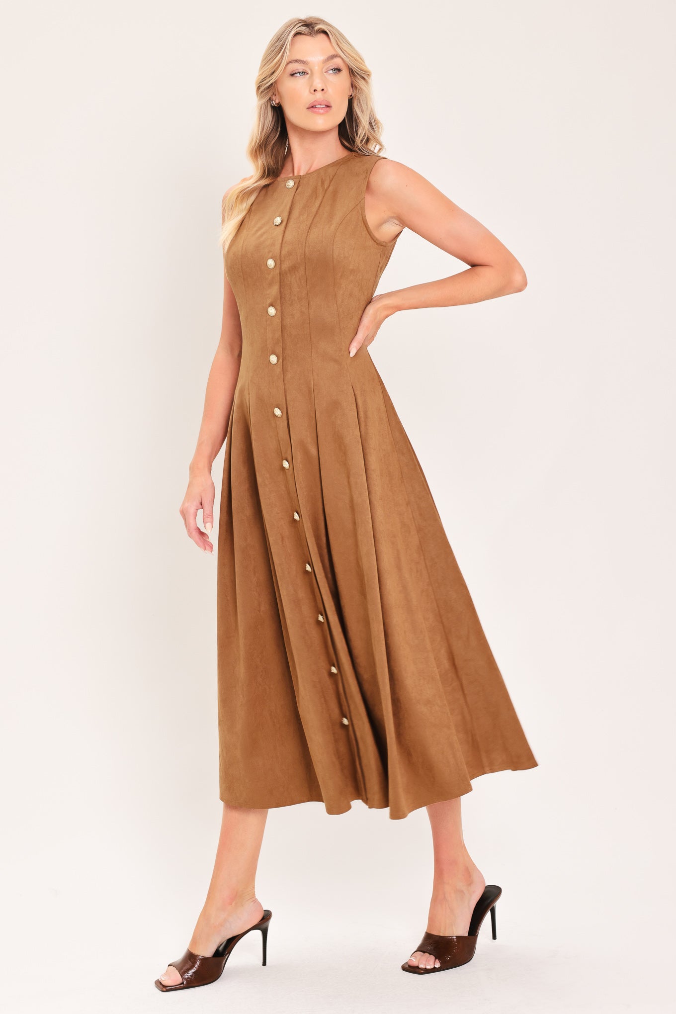 A woman modeling a sleeveless, midi-length camel brown faux suede dress with a button-down front | Flying Tomato