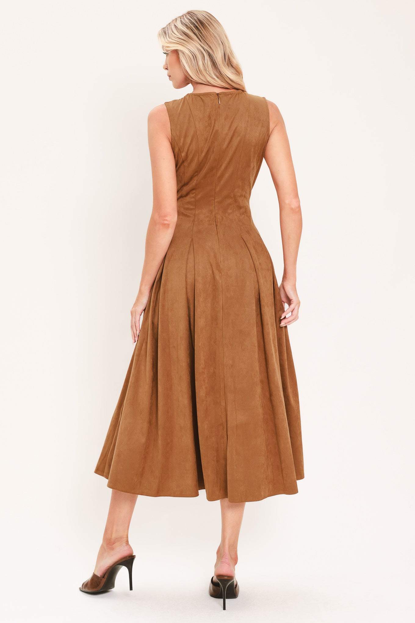 A woman modeling a sleeveless, midi-length camel brown faux suede dress with a button-down front | Flying Tomato