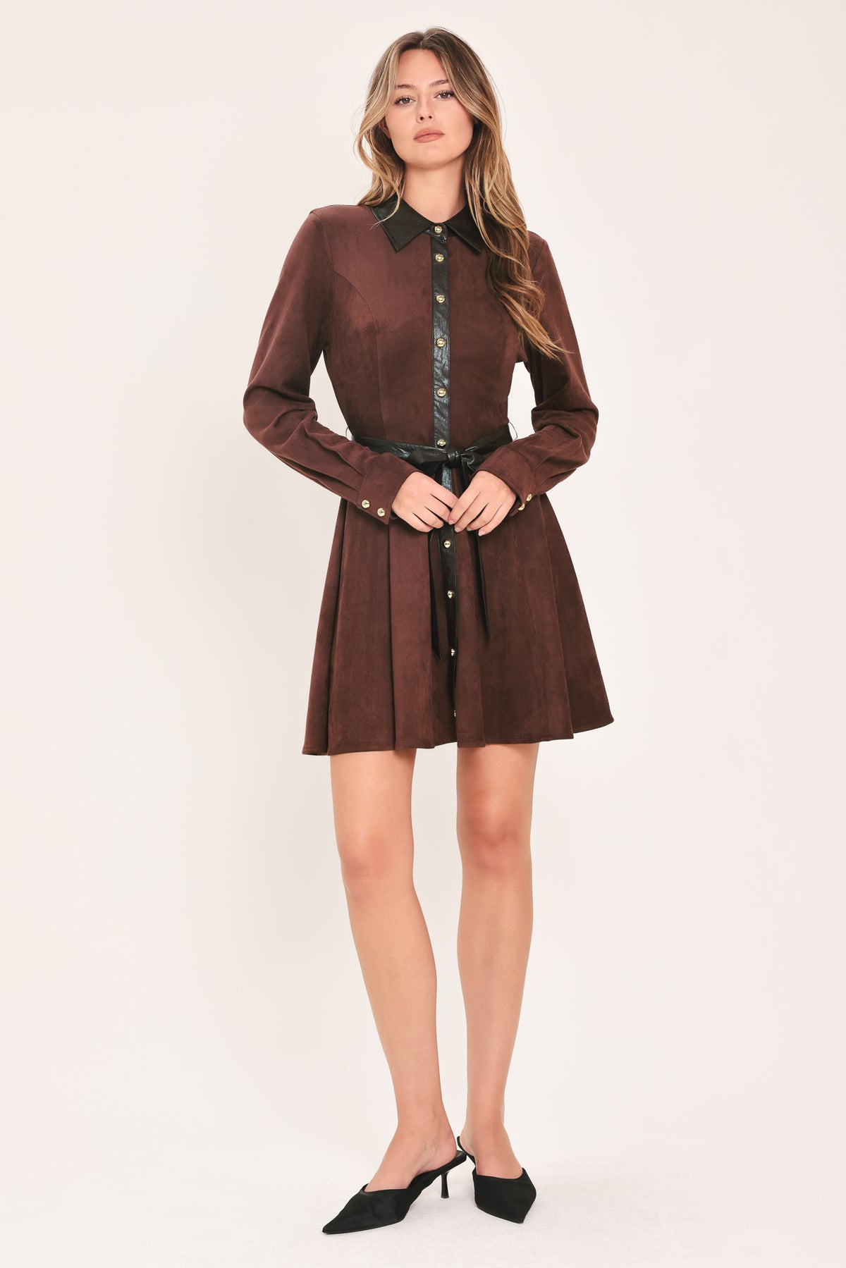 A woman modeling a burgundy suede long-sleeve shirt dress with a black faux-leather collar, button placket, and matching black tie belt | Flying Tomato