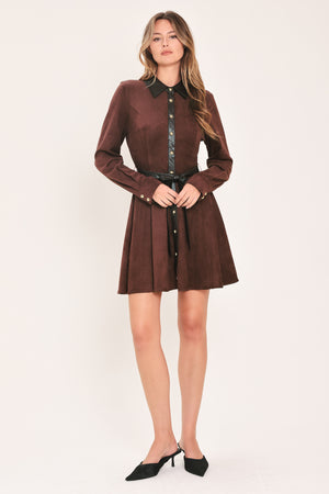 A woman modeling a burgundy suede long-sleeve shirt dress with a black faux-leather collar, button placket, and matching black tie belt | Flying Tomato