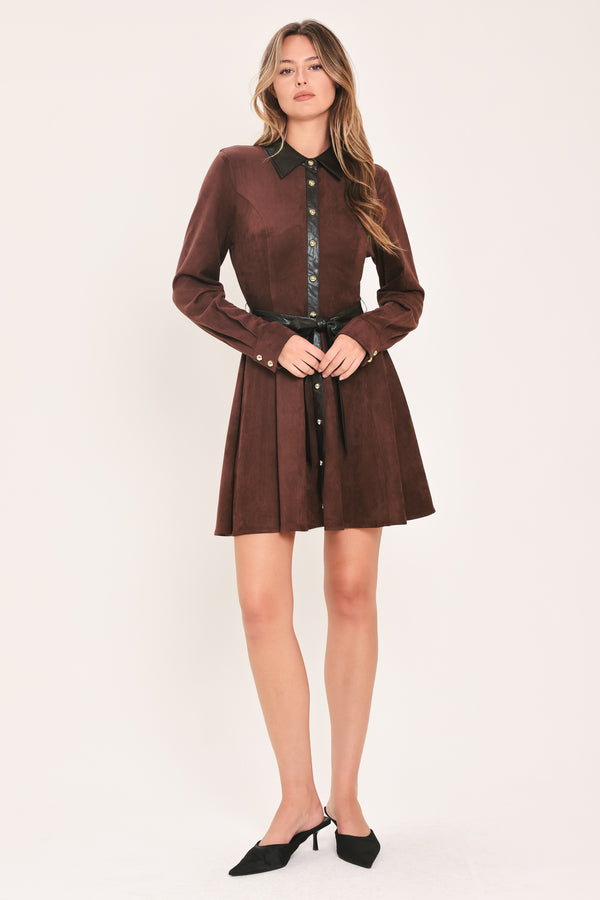 A woman modeling a burgundy suede long-sleeve shirt dress with a black faux-leather collar, button placket, and matching black tie belt | Flying Tomato