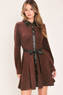 A woman modeling a brown suede long-sleeve shirt dress with a black faux-leather collar, button placket, and matching black tie belt | Flying Tomato