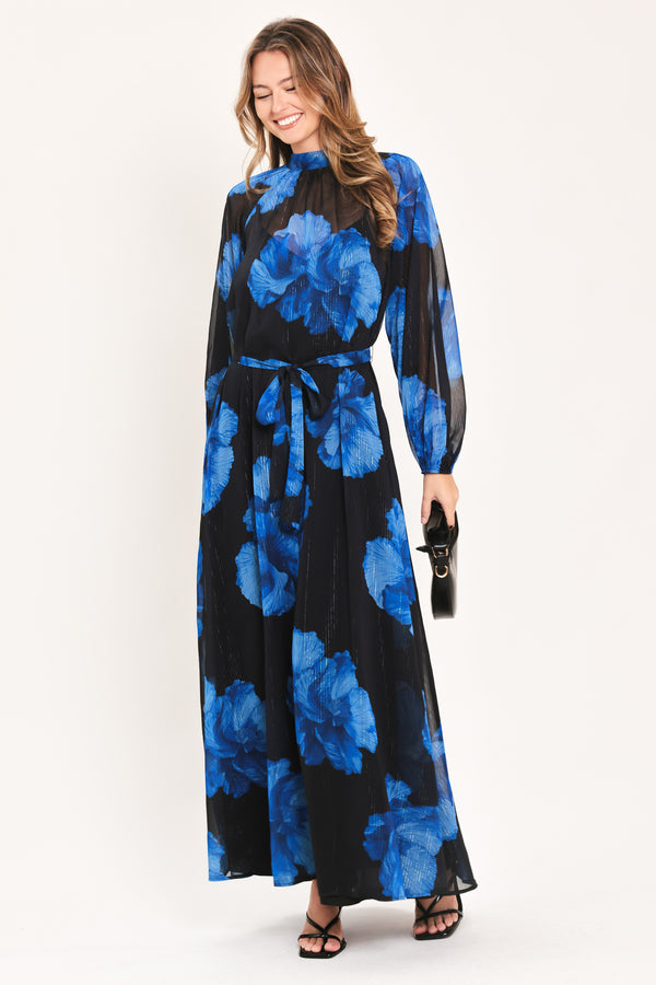 A woman modeling a long-sleeve maxi dress with a black base and a vibrant blue floral print | Flying Tomato