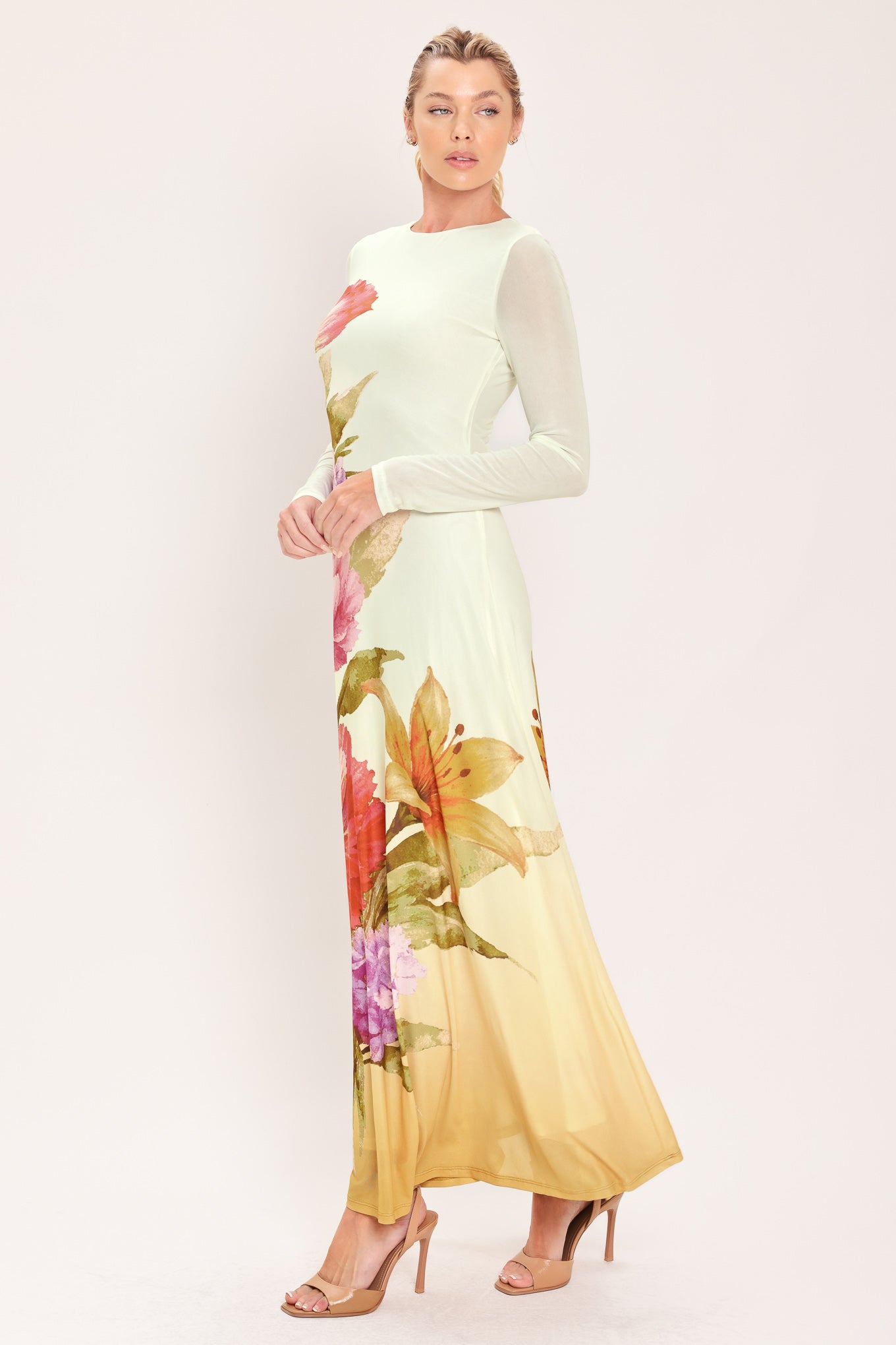 A woman modeling a long-sleeve maxi dress with a large floral print in pink, red, purple, and green | Flying Tomato
