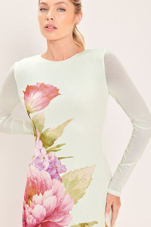 A woman modeling a long-sleeve maxi dress with a large floral print in pink, red, purple, and green | Flying Tomato