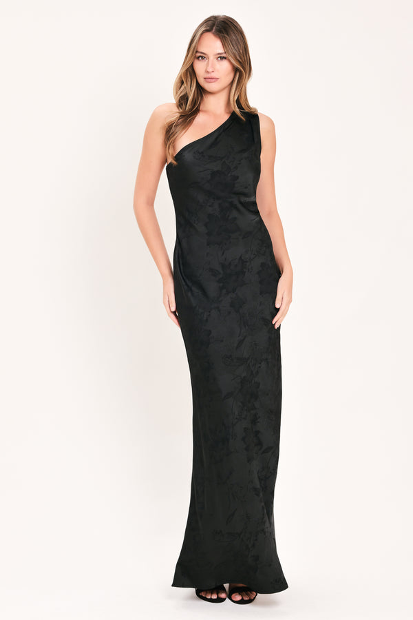 A woman modeling a sleeveless, one-shoulder black maxi dress with a textured jacquard pattern | Flying Tomato