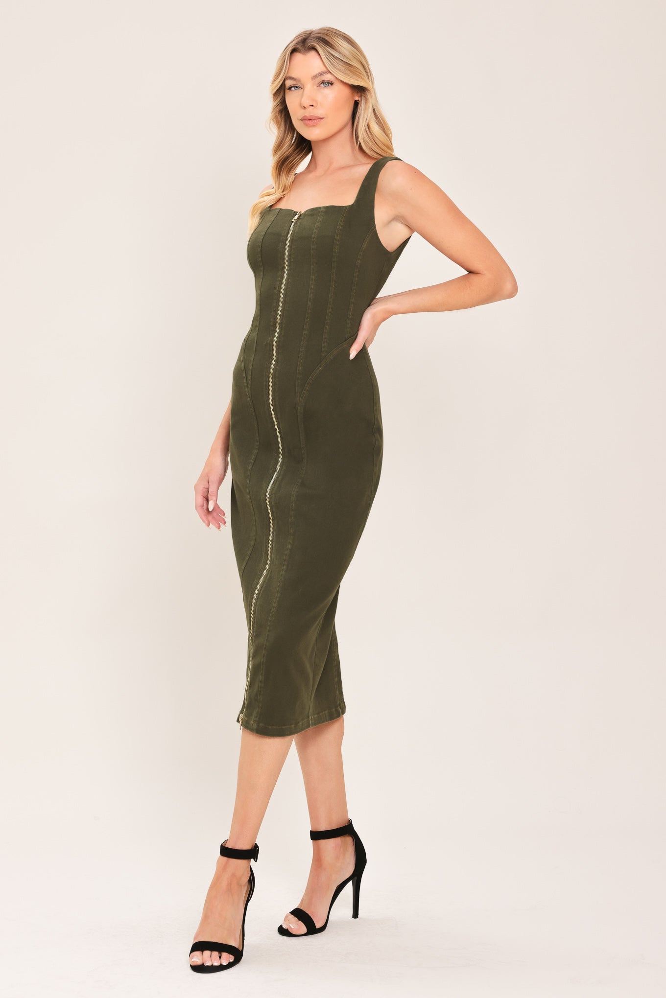 A woman wearing an olive green sleeveless midi dress with a square neckline and front zipper | Flying Tomato