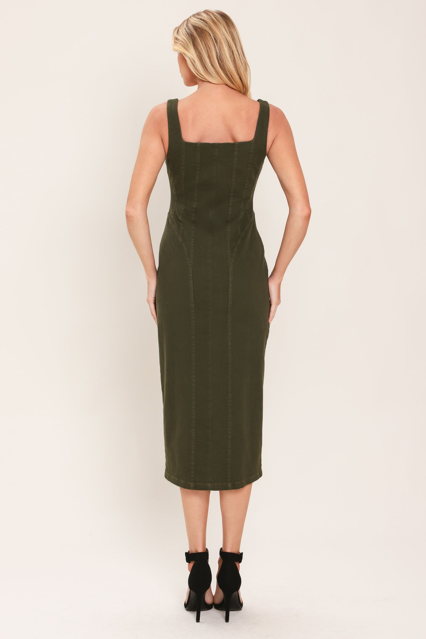 A woman wearing an olive green sleeveless midi dress with a square neckline and front zipper | Flying Tomato