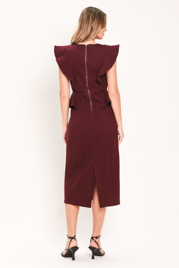 A woman modeling a sleeveless burgundy midi dress with ruffled cap sleeves, a peplum waist, and a front button placket | Flying Tomato