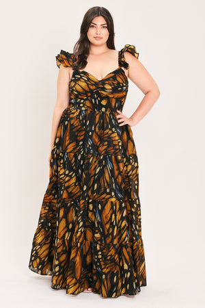 A woman modeling a floor-length tiered maxi dress with a black and orange butterfly wing print, featuring ruffled shoulder straps and a sweetheart neckline, set against a plain light gray studio background | Flying Tomato Curve