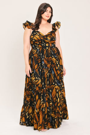 A woman modeling a floor-length tiered maxi dress with a black and orange butterfly wing print, featuring ruffled shoulder straps and a sweetheart neckline, set against a plain light gray studio background | Flying Tomato Curve