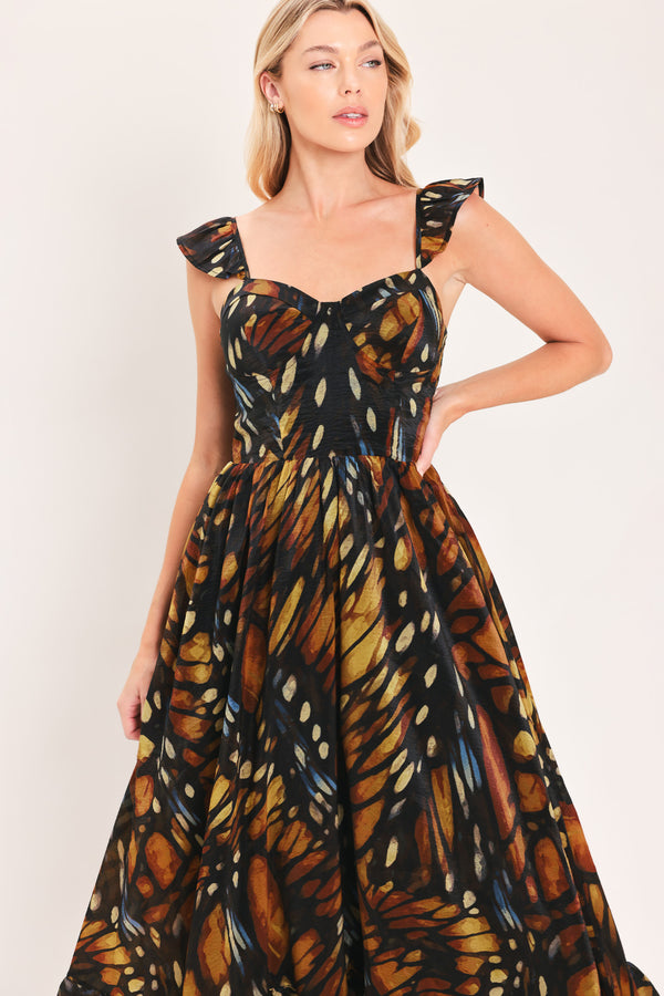 A woman modeling a maxi sleeveless dress with a butterfly wing print in orange, brown, black, and beige tones | Flying Tomato