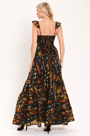 A woman modeling a maxi sleeveless dress with a butterfly wing print in orange, brown, black, and beige tones | Flying Tomato