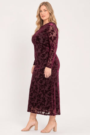 A woman modeling a long-sleeve, midi-length burgundy velvet dress with a tonal floral jacquard pattern | Flying Tomato
