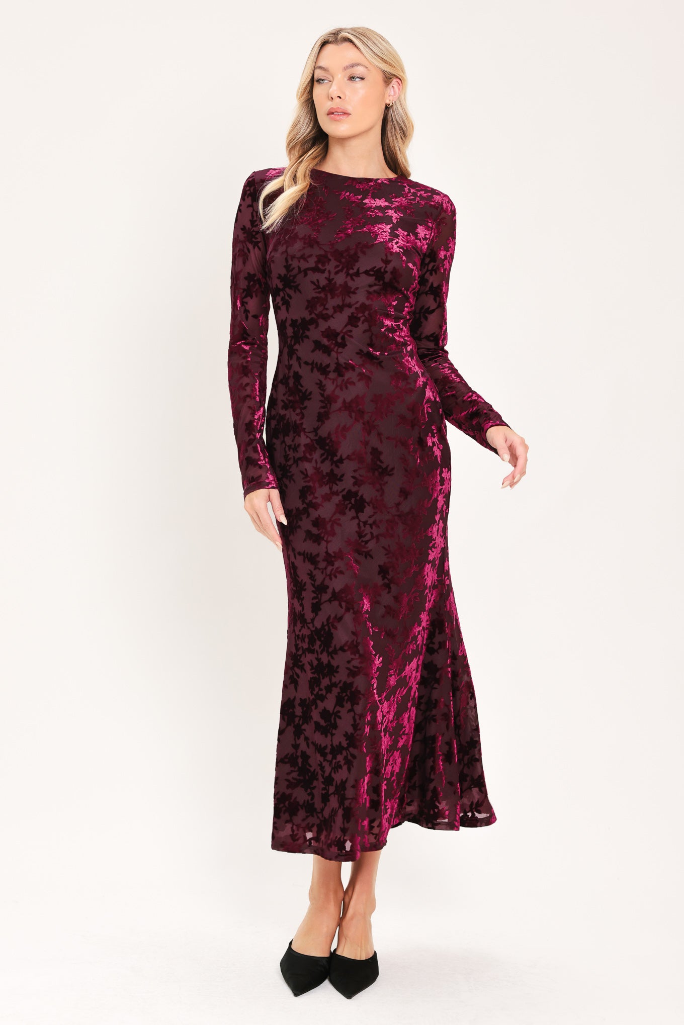 A woman modeling a long-sleeve, midi burgundy velvet dress with an allover tonal floral jacquard pattern | Flying Tomato