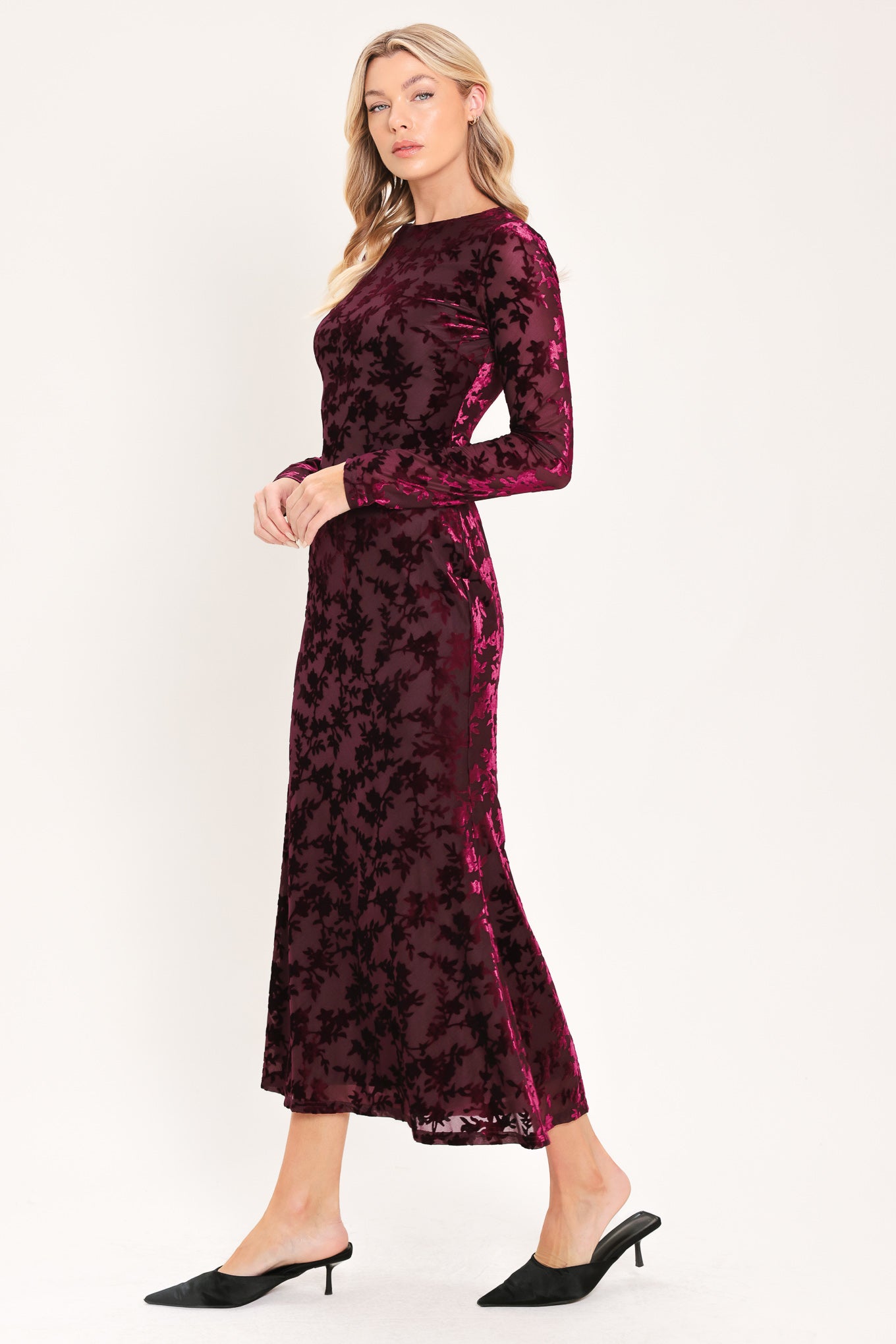 A woman modeling a long-sleeve, midi burgundy velvet dress with an allover tonal floral jacquard pattern | Flying Tomato