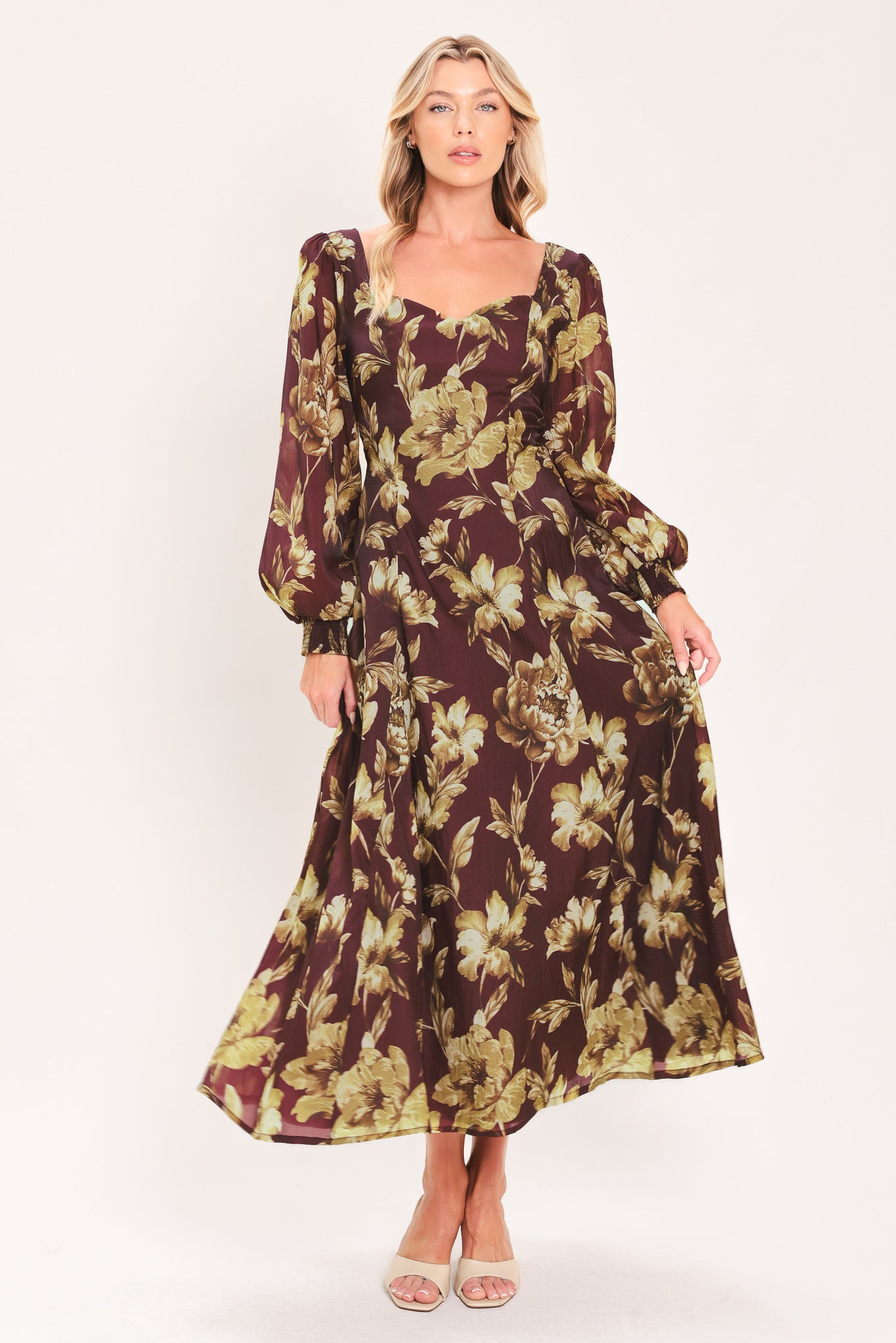 A woman modeling a long-sleeved midi dress with a burgundy and olive green floral pattern | Flying Tomato