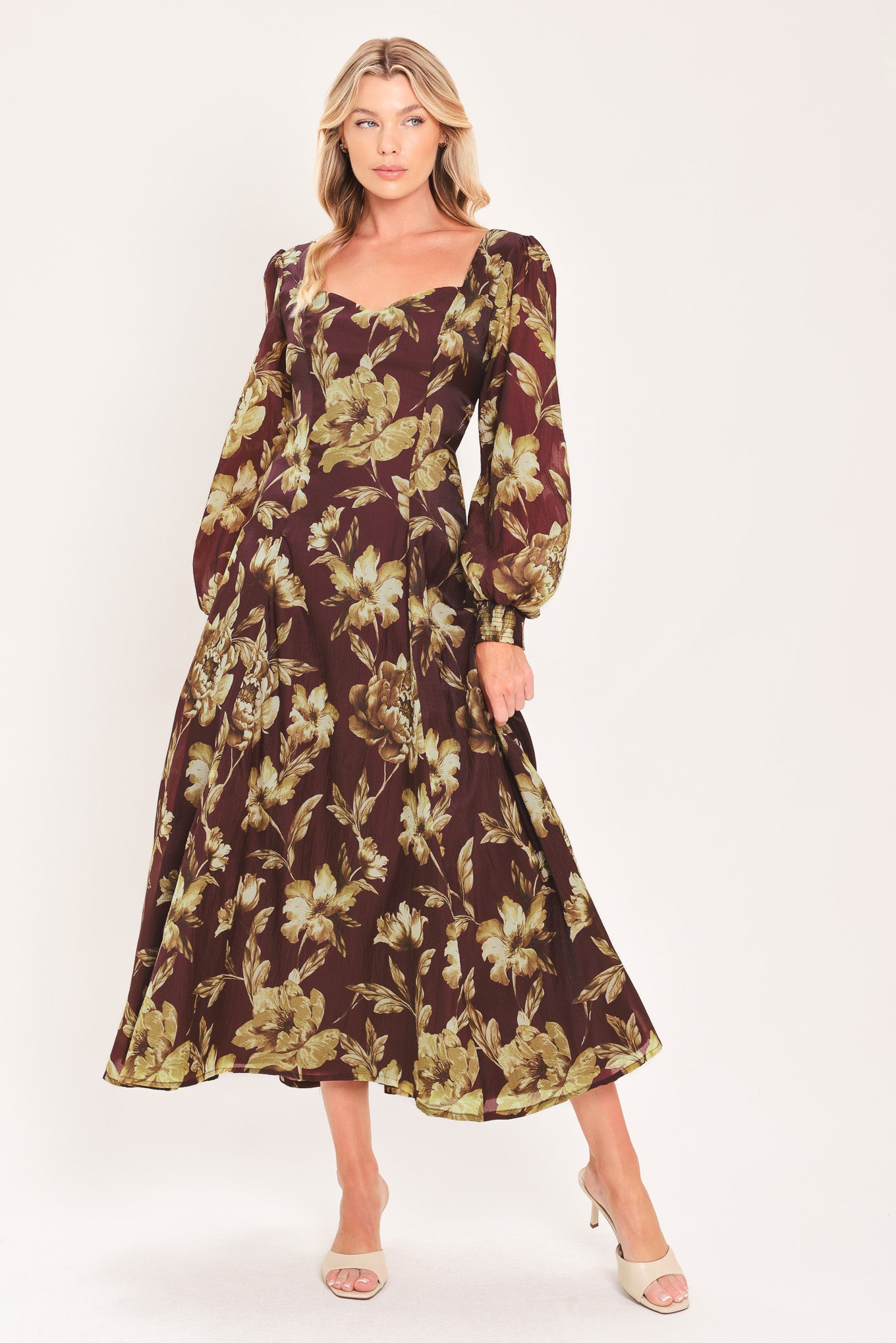 A woman modeling a long-sleeved midi dress with a burgundy and olive green floral pattern | Flying Tomato