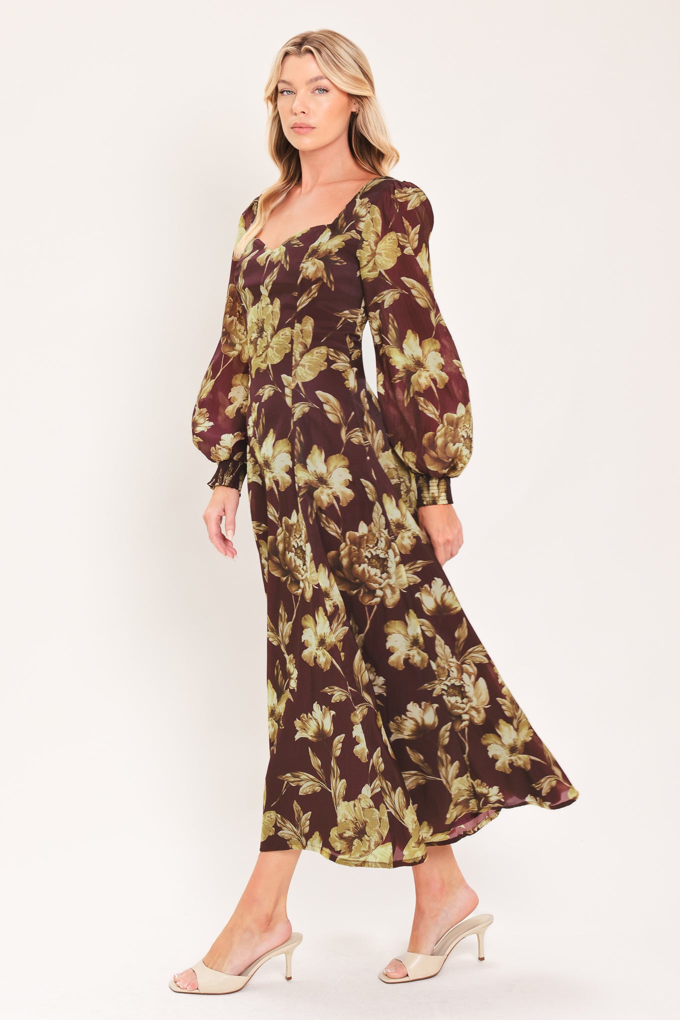 A woman modeling a long-sleeved midi dress with a burgundy and olive green floral pattern | Flying Tomato