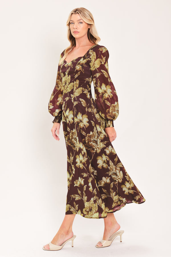 A woman modeling a long-sleeved midi dress with a burgundy and olive green floral pattern | Flying Tomato