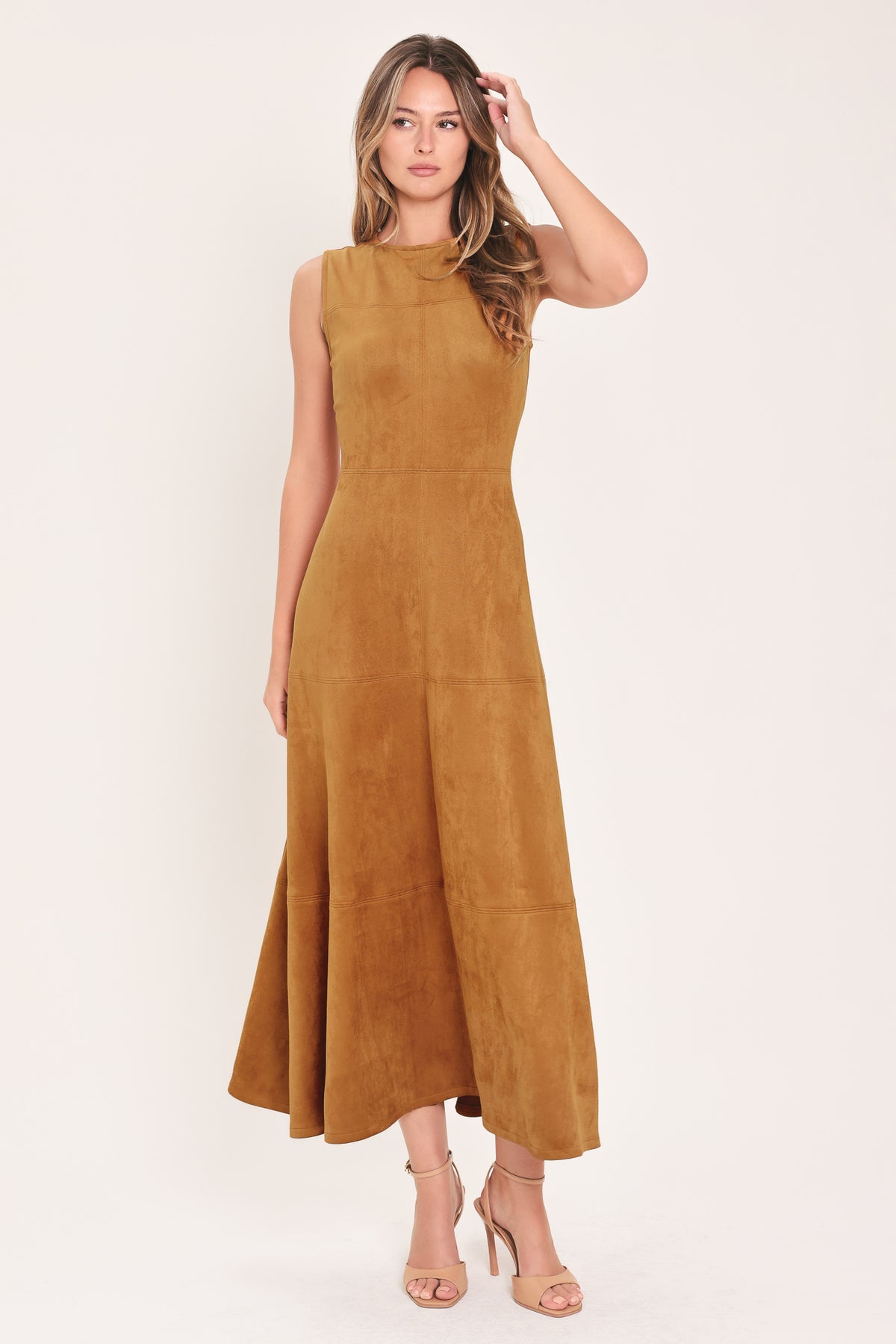 A woman modeling a sleeveless, high-neck, midi-length camel brown dress with a flared skirt | Flying Tomato