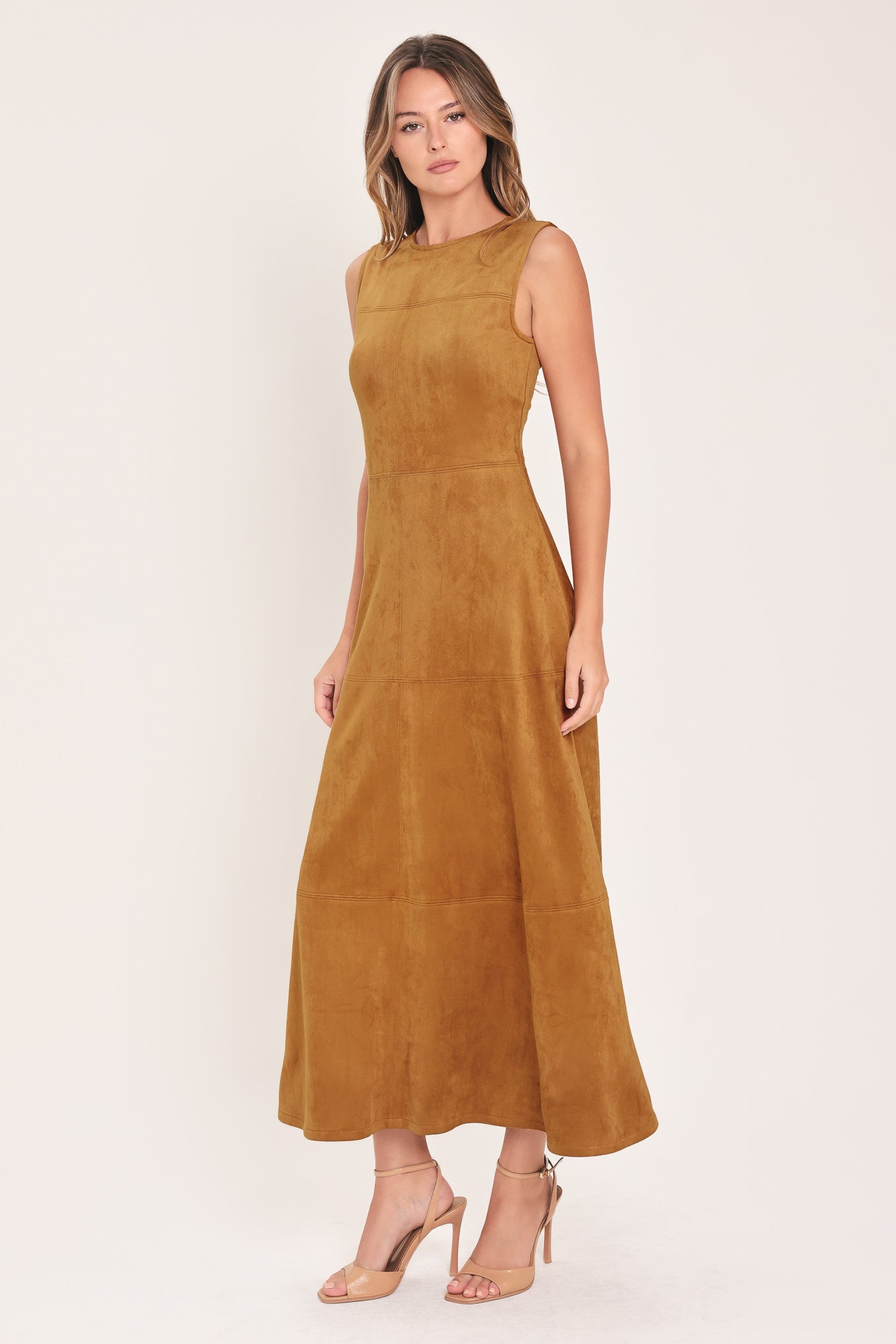 A woman modeling a sleeveless, high-neck, midi-length camel brown dress with a flared skirt | Flying Tomato