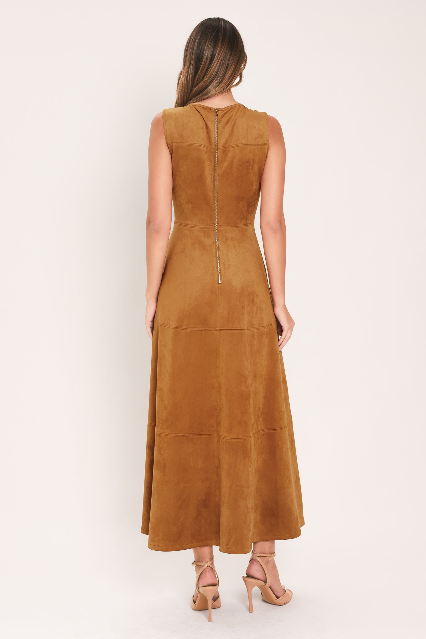 A woman modeling a sleeveless, high-neck, midi-length camel brown dress with a flared skirt | Flying Tomato