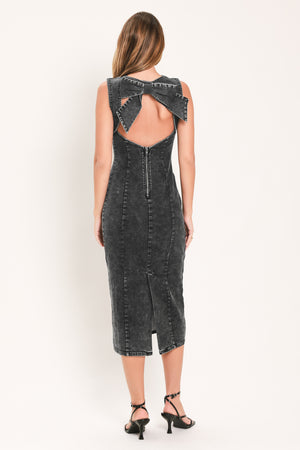 A woman modeling a sleeveless, bodycon midi dress in a washed charcoal gray denim fabric with a large bow detail at the open back | Flying Tomato