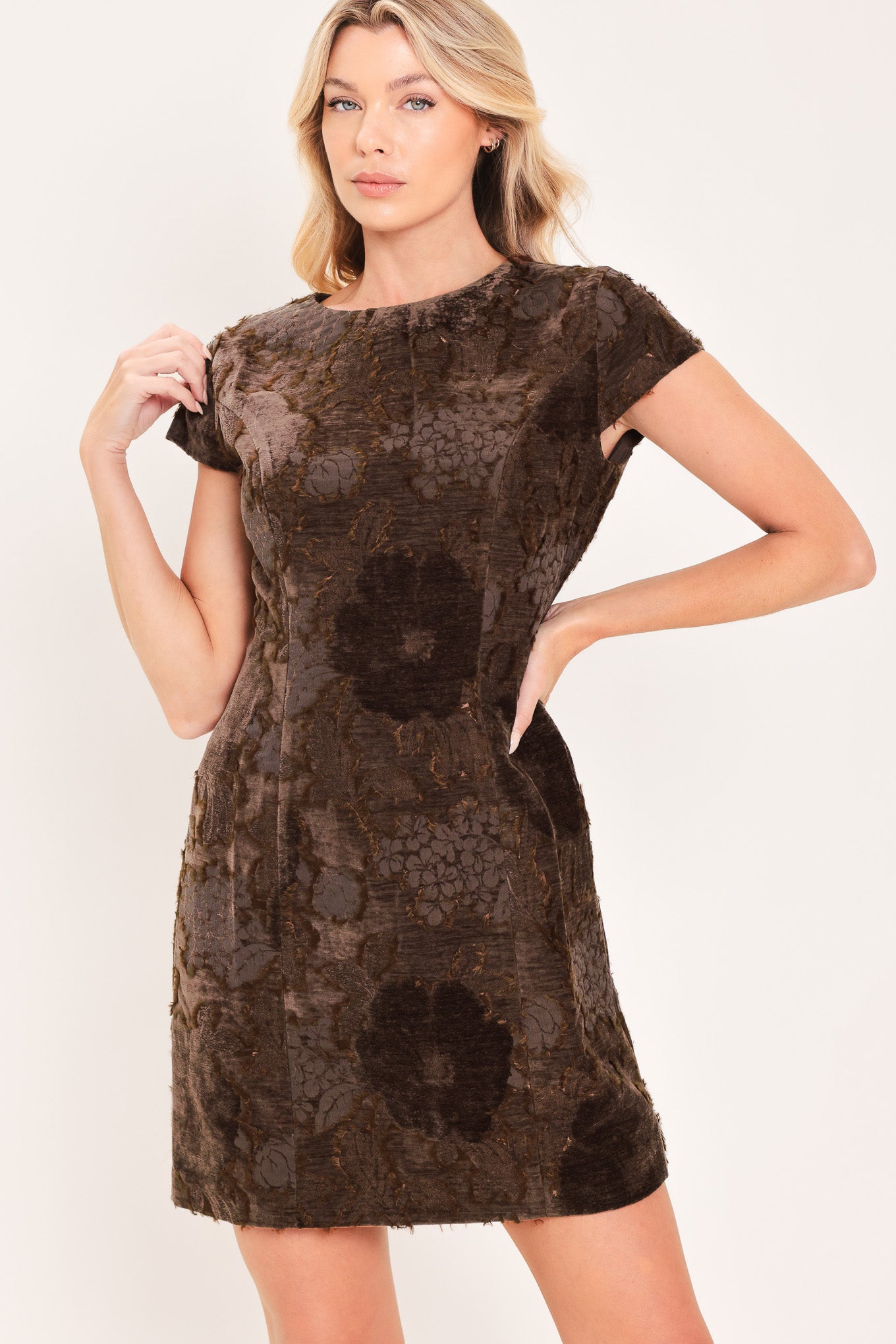 A woman wearing a short-sleeve velvet mini dress with a dark brown floral pattern | Flying Tomato