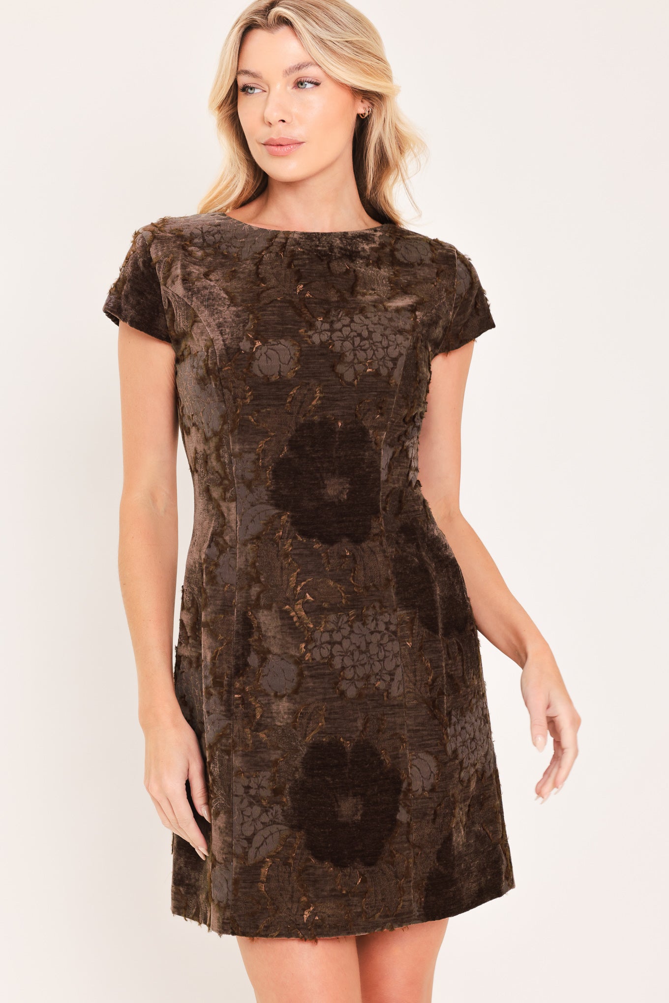 A woman wearing a short-sleeve velvet mini dress with a dark brown floral pattern | Flying Tomato