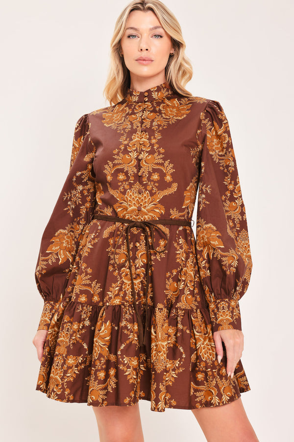 A woman modeling a brown and gold damask-patterned long-sleeve mini dress with a high mock neck and a matching waist tie | Flying Tomato
