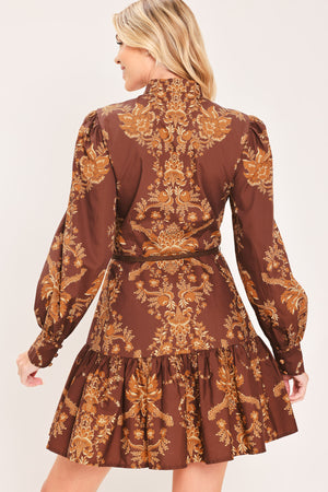 A woman modeling a brown and gold damask-patterned long-sleeve mini dress with a high mock neck and a matching waist tie | Flying Tomato