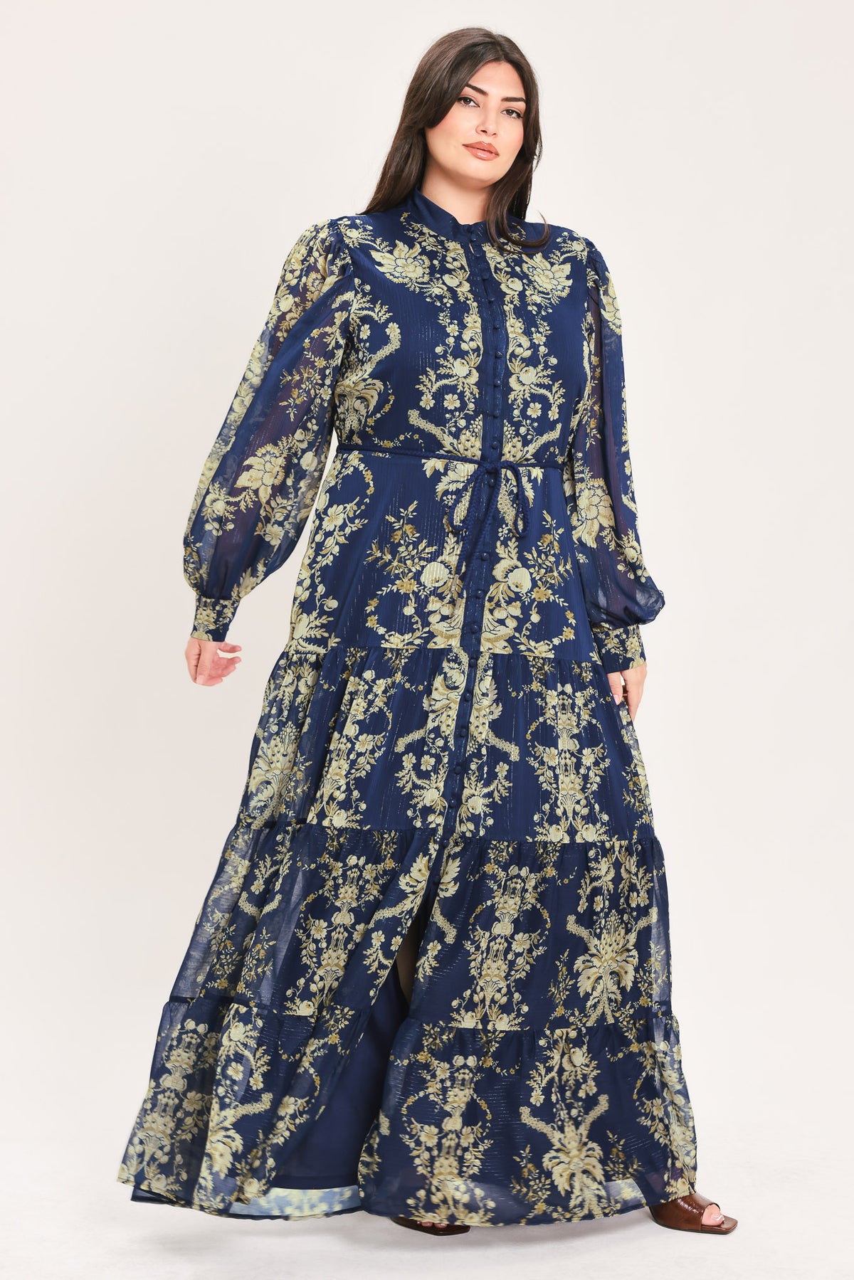 A woman modeling a long-sleeved navy blue maxi dress with a taupe toile floral pattern | Flying Tomato Curve