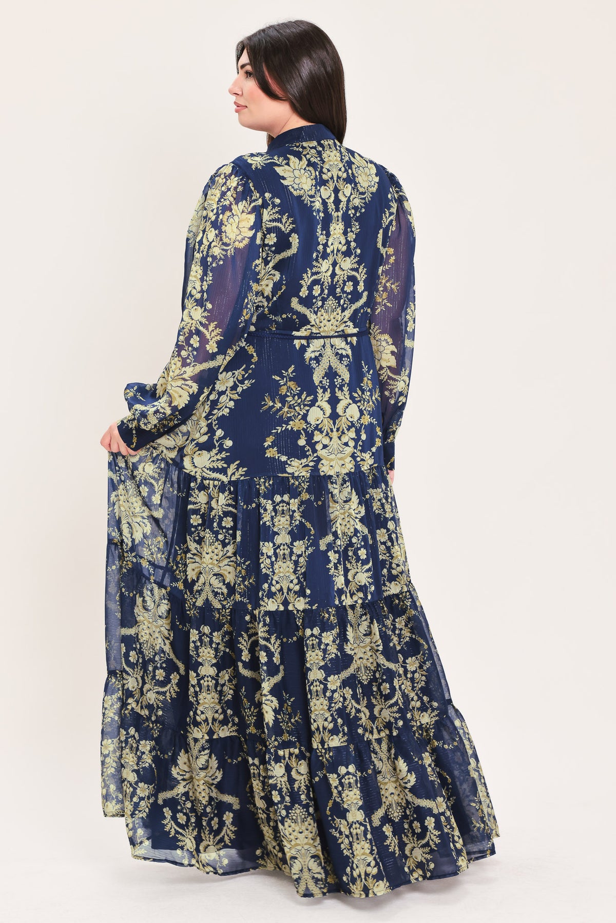 A woman modeling a long-sleeved navy blue maxi dress with a taupe toile floral pattern | Flying Tomato Curve