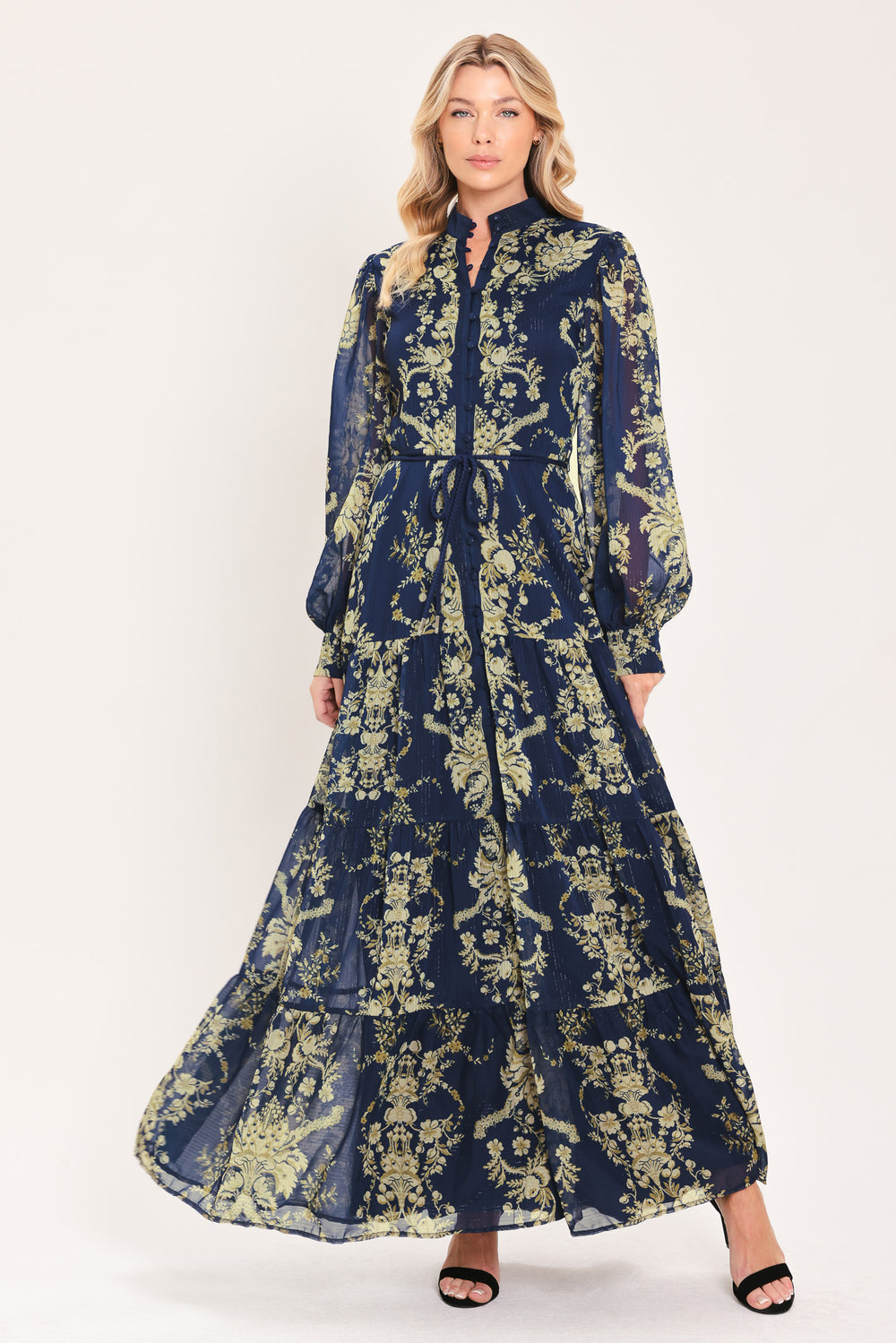 A woman modeling a long-sleeved navy blue maxi dress with a taupe toile floral pattern | Flying Tomato