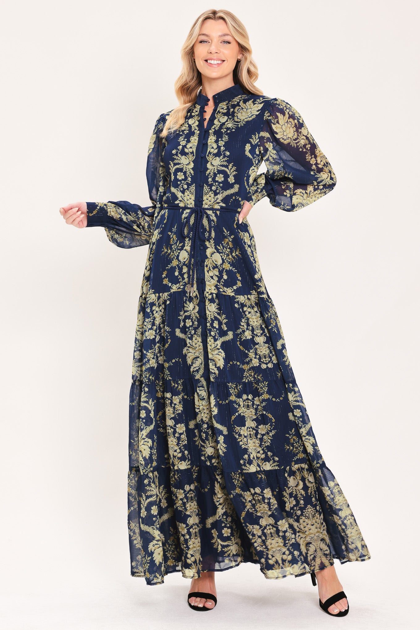 A woman modeling a long-sleeved navy blue maxi dress with a taupe toile floral pattern | Flying Tomato